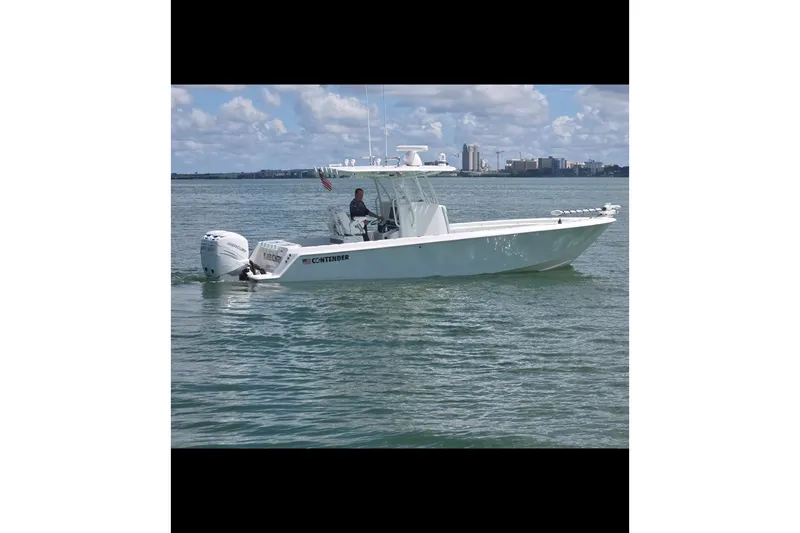 Slide: The Image of 2019 Contender 30 ST boat cruising on calm waters under a partly cloudy sky. - 2
