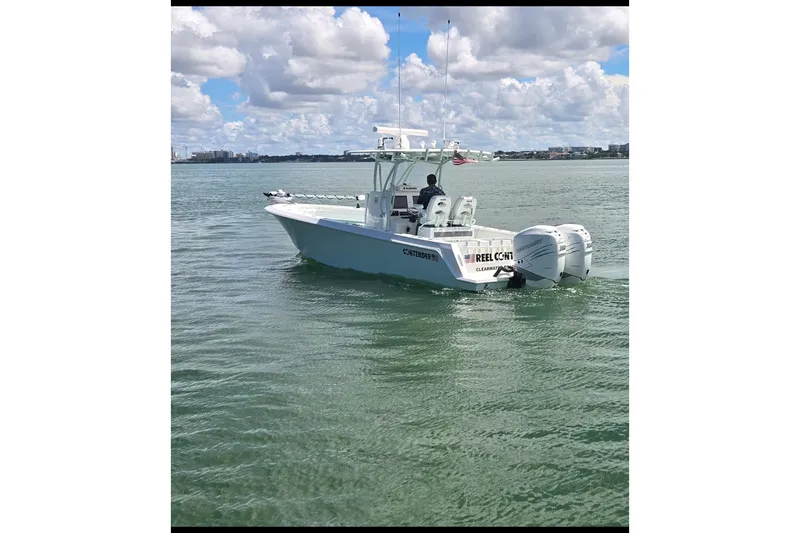 Slide: The Image of 2019 Contender 30 ST boat cruising on calm waters under a partly cloudy sky. - 11