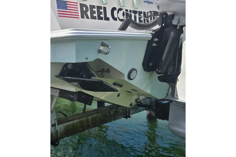 Slide: The Image of 2019 Contender 30 ST boat stern with American flag decal, docked on water. - 23