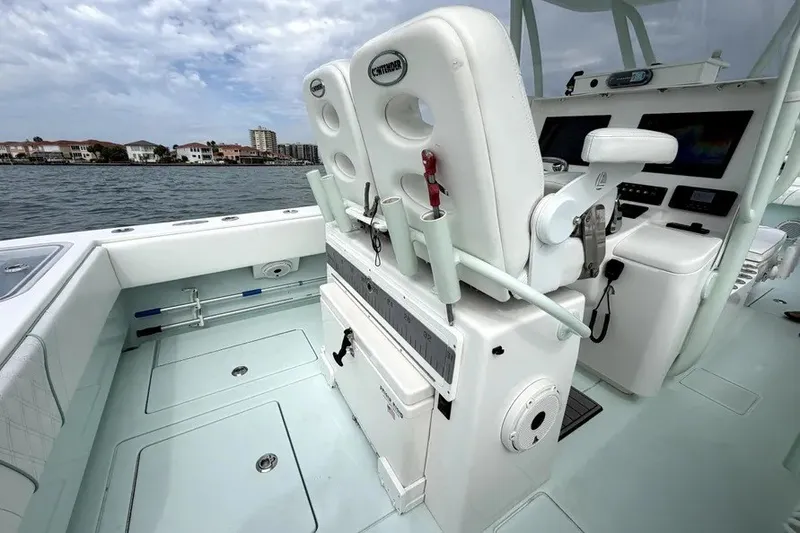 Slide: The Image of 2019 Contender 30 ST boat interior with helm station and seating, docked near waterfront homes. - 12