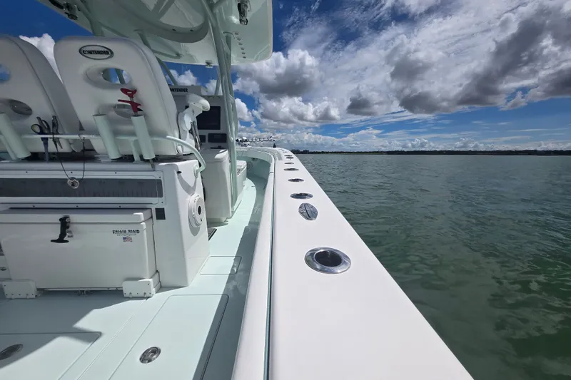 Slide: The Image of 2019 Contender 30 ST boat on calm water under a partly cloudy sky. - 55