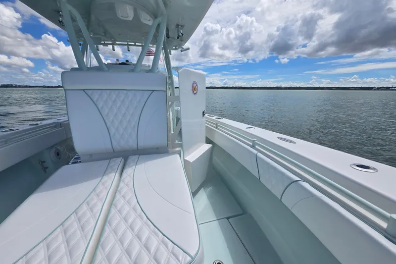 Slide: The Image of 2019 Contender 30 ST boat interior with white seating, on calm water under a cloudy sky. - 31