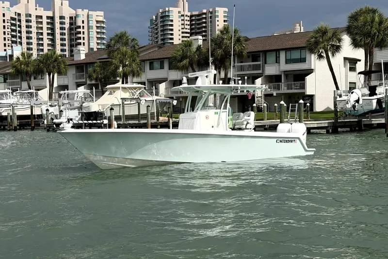 The Image of 2019 Contender 30 ST boat docked near waterfront buildings and palm trees. - 0