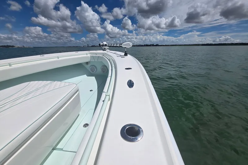 Slide: The Image of 2019 Contender 30 ST boat on calm water under a partly cloudy sky. - 61
