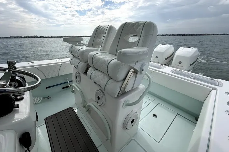 Slide: The Image of 2019 Contender 30 ST boat interior with plush seating and triple outboard engines. - 10