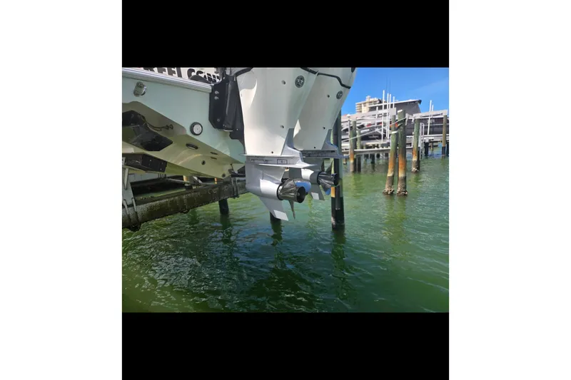 Slide: The Image of 2019 Contender 30 ST boat engines above water near dock. - 20