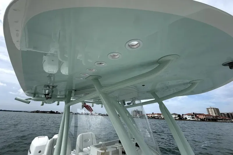 Slide: The Image of 2019 Contender 30 ST boat with T-top, on water near coastal buildings. - 16
