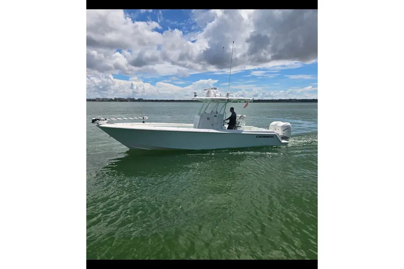 Slide: The Image of 2019 Contender 30 ST boat cruising on calm waters under a partly cloudy sky. - 10