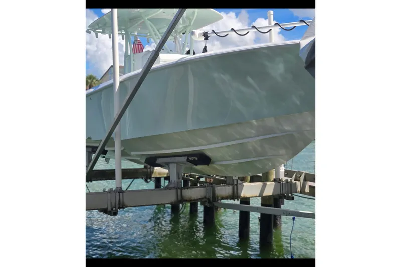 Slide: The Image of 2019 Contender 30 ST boat on lift over water, sunny day. - 18