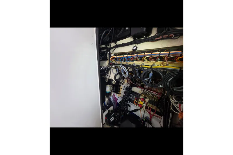 Slide: The Image of Electrical wiring setup inside a 2019 Contender 30 ST boat, showcasing organized cables and components. - 74