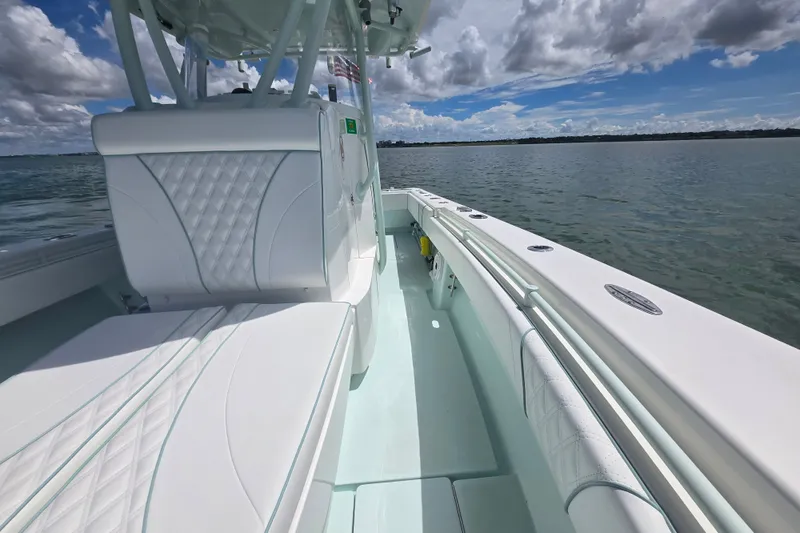Slide: The Image of 2019 Contender 30 ST boat interior with white seating, on calm water under a cloudy sky. - 30