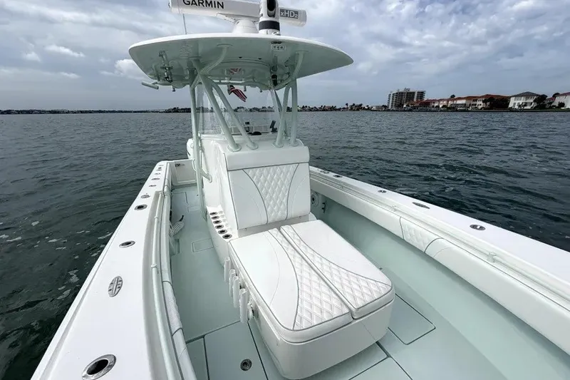 Slide: The Image of 2019 Contender 30 ST boat with cushioned seating on calm waters. - 17