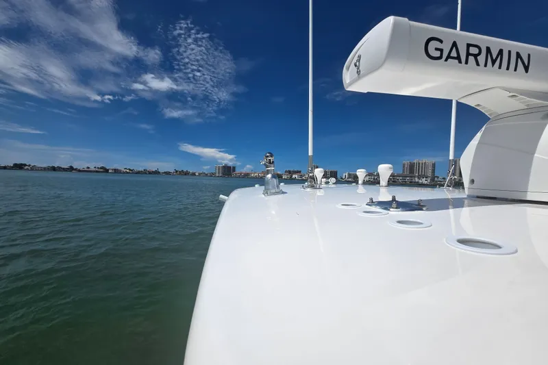 Slide: The Image of 2019 Contender 30 ST boat with Garmin equipment on calm water under blue sky. - 27