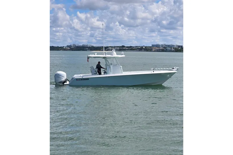 Slide: The Image of 2019 Contender 30 ST boat on calm water under a partly cloudy sky. - 15