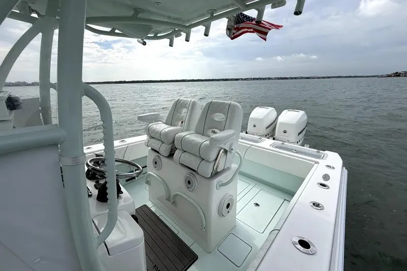 Slide: The Image of 2019 Contender 30 ST boat interior with seating and triple outboard motors on open water. - 9