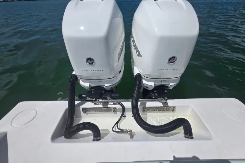 Slide: The Image of Twin Mercury outboard engines on a 2019 Contender 30 ST boat, docked on calm water. - 75
