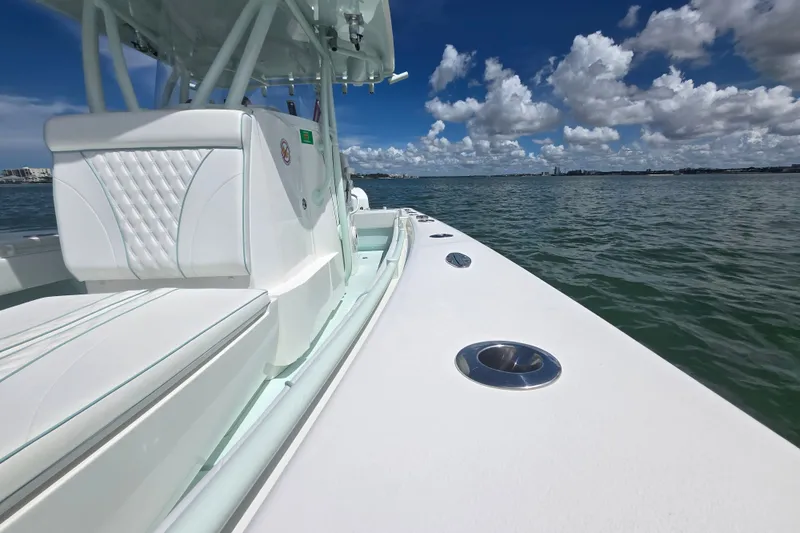 Slide: The Image of 2019 Contender 30 ST boat on water, featuring sleek white design and clear blue sky. - 32