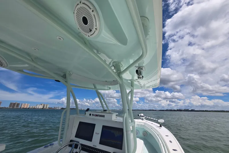 Slide: The Image of 2019 Contender 30 ST boat on water, featuring electronics and clear sky. - 57
