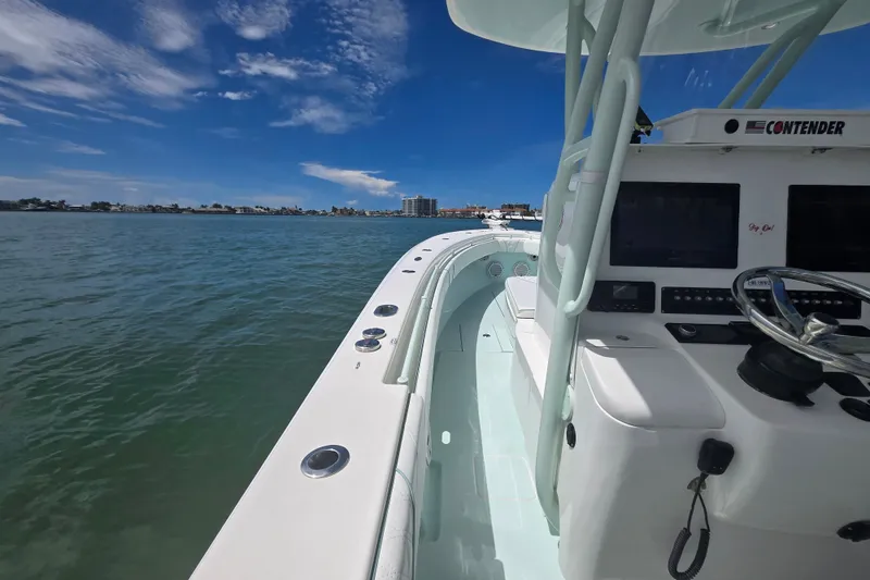 Slide: The Image of 2019 Contender 30 ST boat on calm water, featuring a sleek design and modern dashboard. - 50