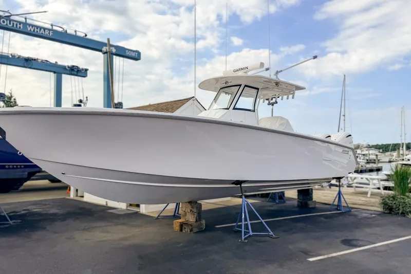 The Image of 2027 Jupiter 340 LS boat on stands at a marina, clear sky background. - 0