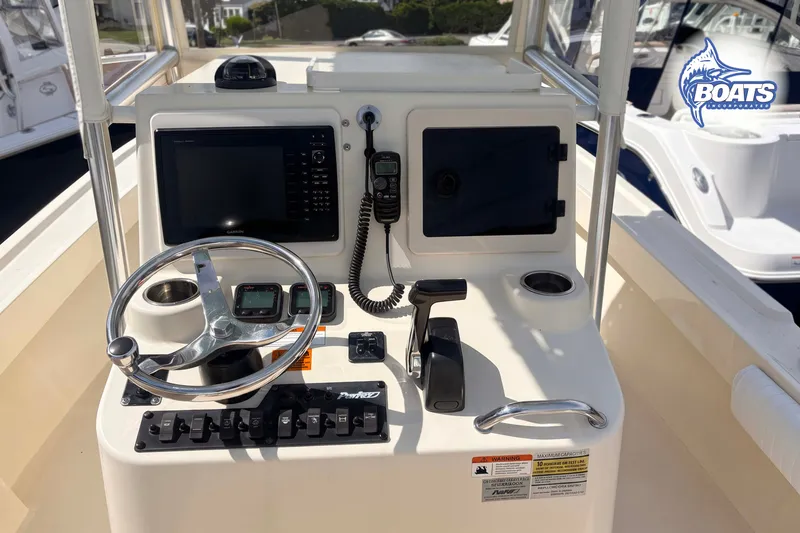 Slide: The Image of Control panel of a 2013 Parker 2300 Special Edition boat with steering wheel and navigation equipment. - 4
