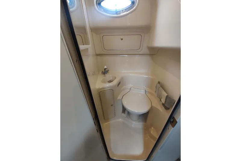 Slide: The Image of Compact bathroom in 2000 Sea Ray Sundancer 400 yacht with toilet, sink, and porthole. - 26