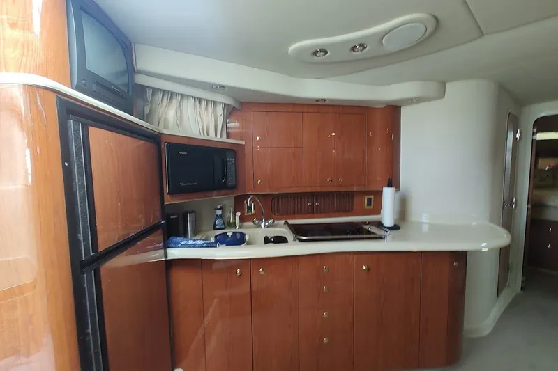 Slide: The Image of Interior of 2000 Sea Ray Sundancer 400 yacht kitchen with wood cabinets and appliances. - 23