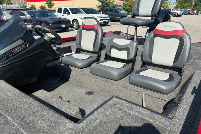 Slide: The Image of 2019 Lowe Stinger 175C boat interior with three gray and red seats. - 12