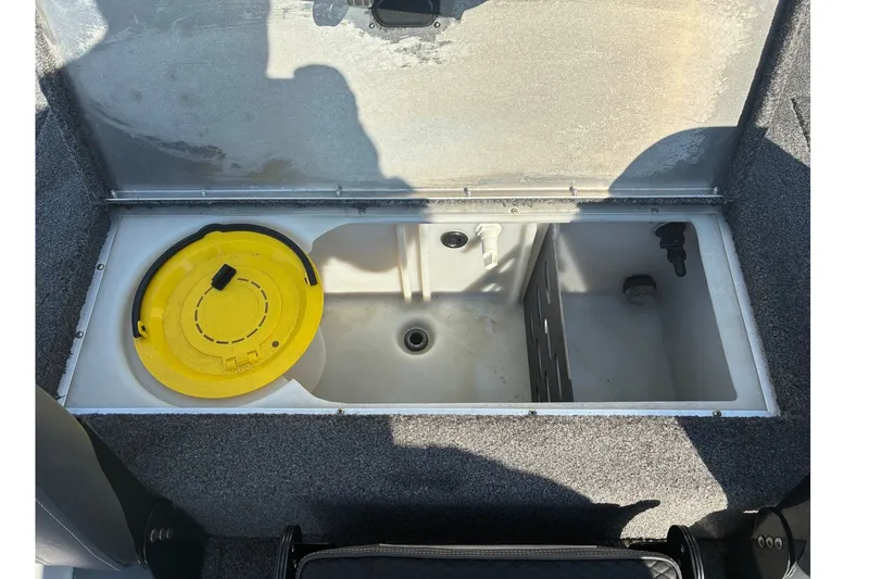 Slide: The Image of Open storage compartment in a 2019 Lowe Stinger 175C boat with yellow lid. - 17