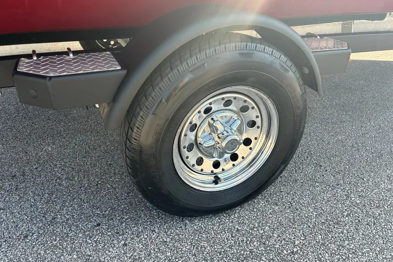 Slide: The Image of 2019 Lowe Stinger 175C trailer wheel on asphalt, featuring chrome rim and diamond plate step. - 6