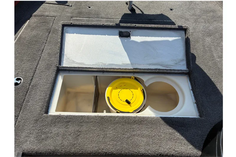 Slide: The Image of 2019 Lowe Stinger 175C boat storage compartment with yellow lid. - 18