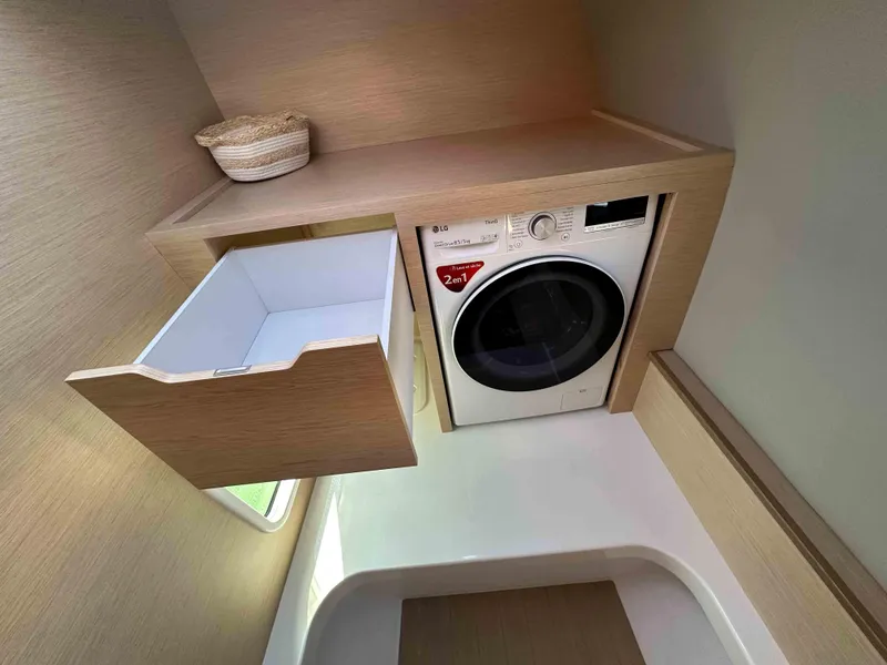 Slide: The Image of Laundry area in NEEL 52, 2025 model, featuring a washer and storage drawer. - 15