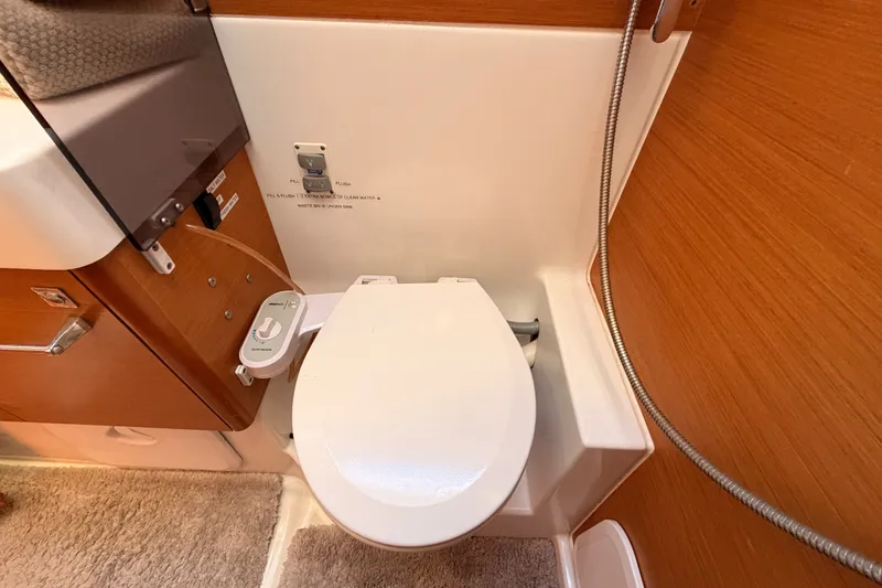 Slide: The Image of 2014 Jeanneau Sun Odyssey 509 yacht bathroom with modern toilet and wooden cabinetry. - 63