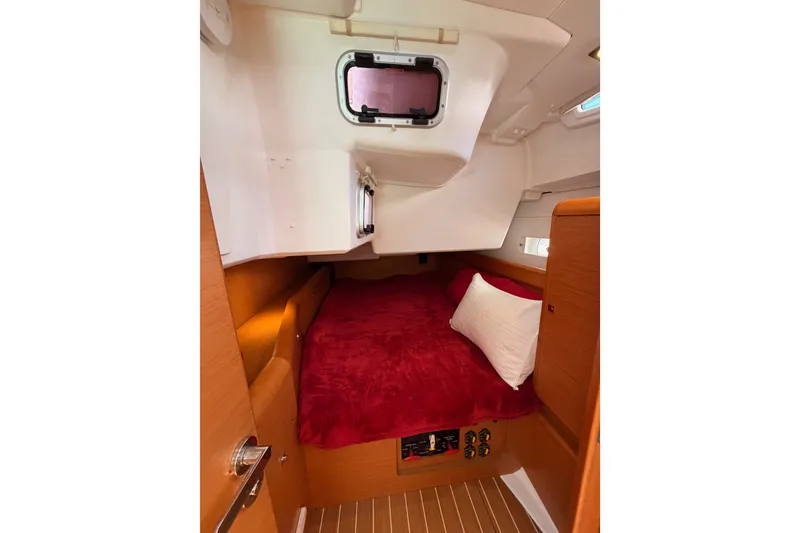 Slide: The Image of Cozy cabin interior of 2014 Jeanneau Sun Odyssey 509 with red bedding and wooden accents. - 67