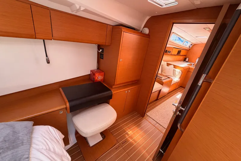 Slide: The Image of Interior of 2014 Jeanneau Sun Odyssey 509 yacht, featuring elegant wood finish and cozy seating. - 93