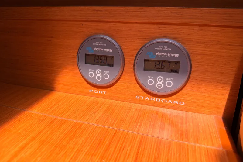 Slide: The Image of Battery monitors on Jeanneau Sun Odyssey 509 yacht, displaying port and starboard voltages. - 74
