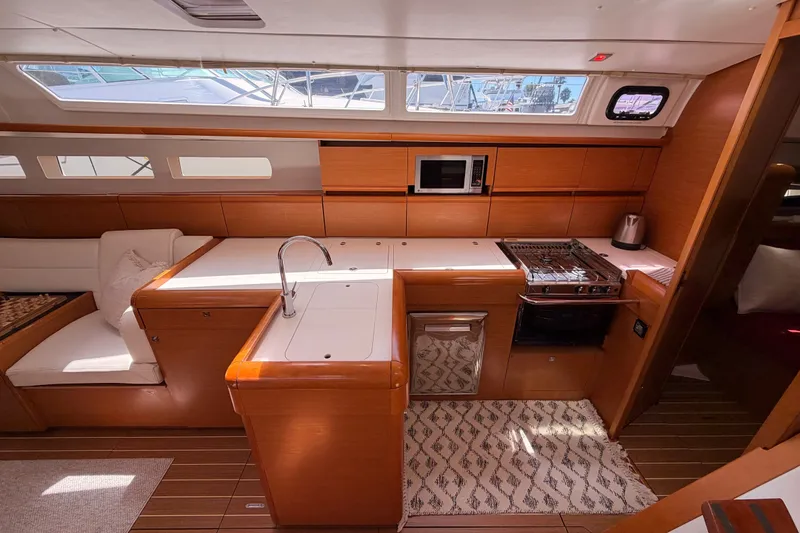 Slide: The Image of Interior of 2014 Jeanneau Sun Odyssey 509 yacht, featuring modern kitchen and seating area. - 53