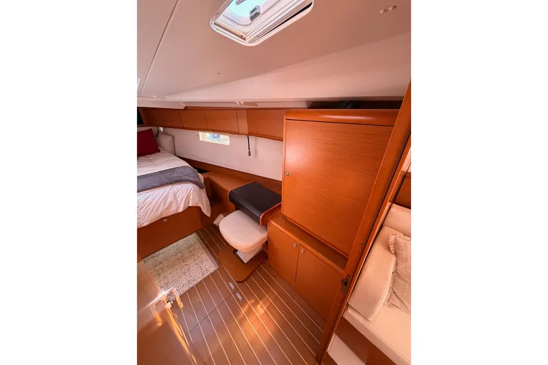 Slide: The Image of Interior cabin of 2014 Jeanneau Sun Odyssey 509 yacht, featuring wood finish and cozy bedding. - 85