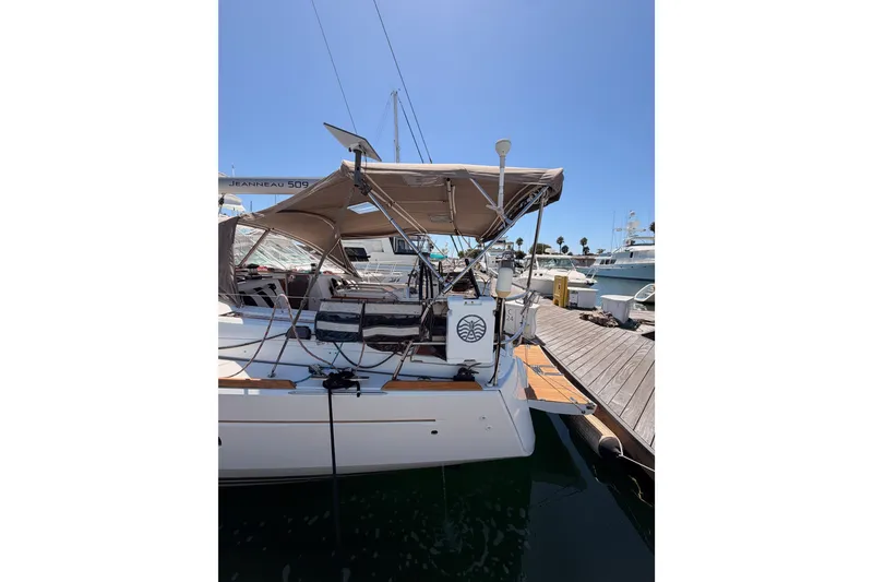 Slide: The Image of 2014 Jeanneau Sun Odyssey 509 yacht docked at marina under clear blue sky. - 14