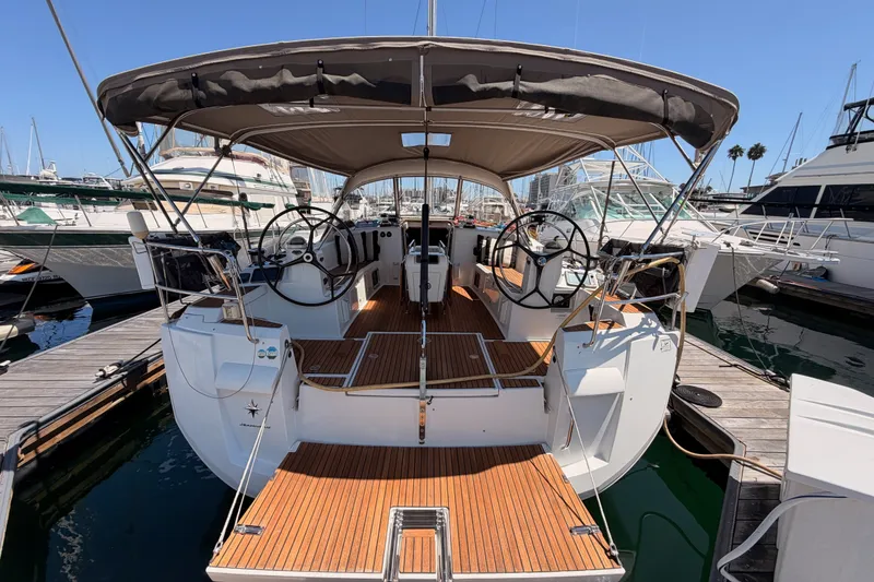 Slide: The Image of 2014 Jeanneau Sun Odyssey 509 sailboat docked, featuring dual steering wheels and teak decking. - 15