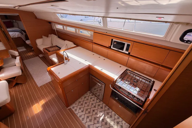 Slide: The Image of Interior of 2014 Jeanneau Sun Odyssey 509 yacht with modern kitchen and seating area. - 52