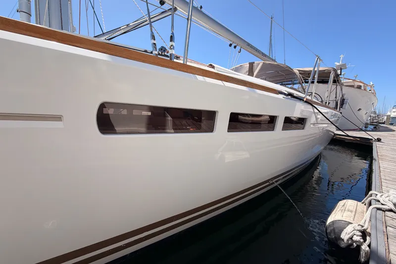 Slide: The Image of 2014 Jeanneau Sun Odyssey 509 yacht docked at marina, showcasing sleek design and modern features. - 11