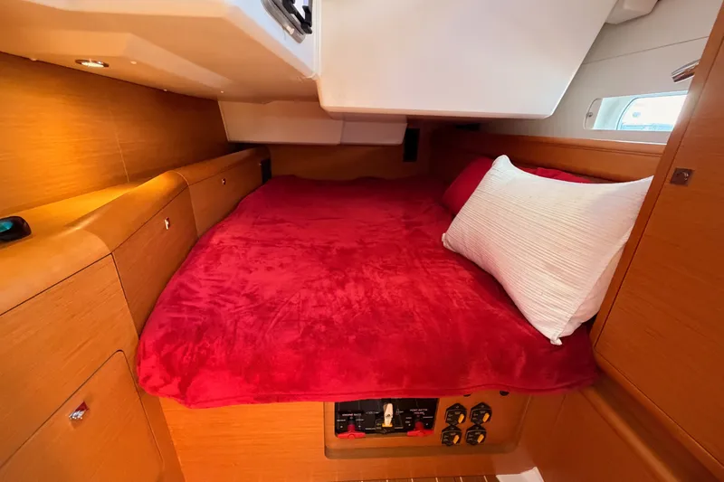 Slide: The Image of Cozy cabin interior of 2014 Jeanneau Sun Odyssey 509 with red bedding and wooden finish. - 68