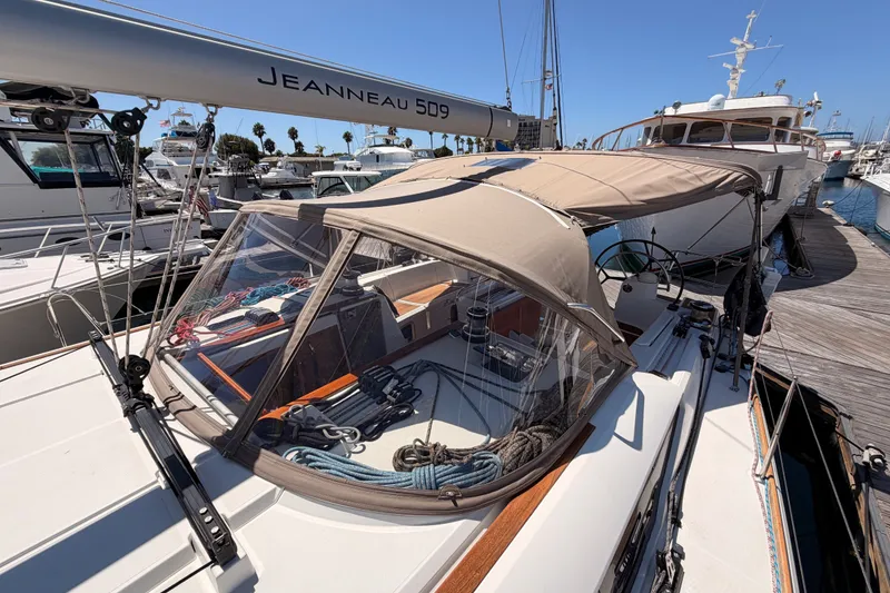 Slide: The Image of 2014 Jeanneau Sun Odyssey 509 sailboat docked at marina, featuring cockpit and canopy. - 45