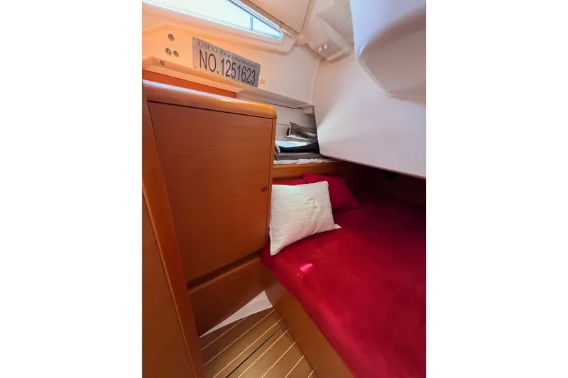 Slide: The Image of Cozy cabin interior of 2014 Jeanneau Sun Odyssey 509 with red bedding and wooden accents. - 59