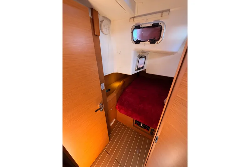 Slide: The Image of Cozy cabin interior of 2014 Jeanneau Sun Odyssey 509 sailboat with red bedding. - 66