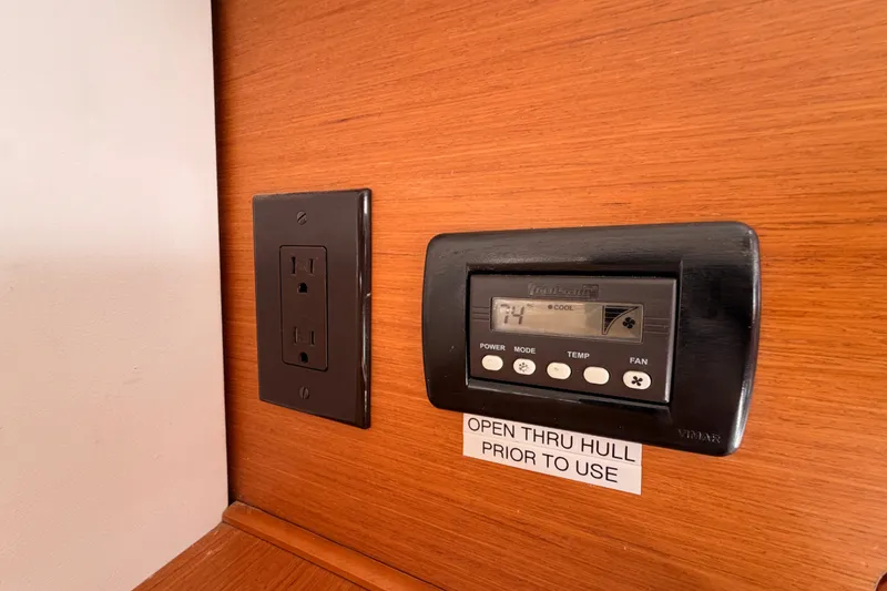 Slide: The Image of Thermostat and outlet on Jeanneau Sun Odyssey 509 yacht, 2014 model, with wood paneling. - 104