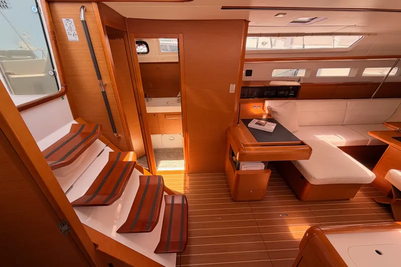 Slide: The Image of Interior of 2014 Jeanneau Sun Odyssey 509 yacht, featuring wooden flooring and cozy seating area. - 60