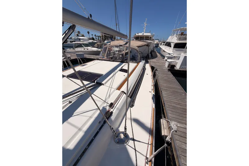 Slide: The Image of 2014 Jeanneau Sun Odyssey 509 sailboat docked at marina, showcasing sleek deck design. - 44