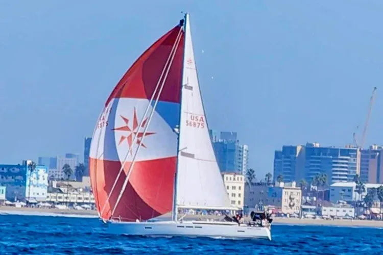 Slide: The Image of 2014 Jeanneau Sun Odyssey 509 sailing near urban coastline with colorful spinnaker. - 4